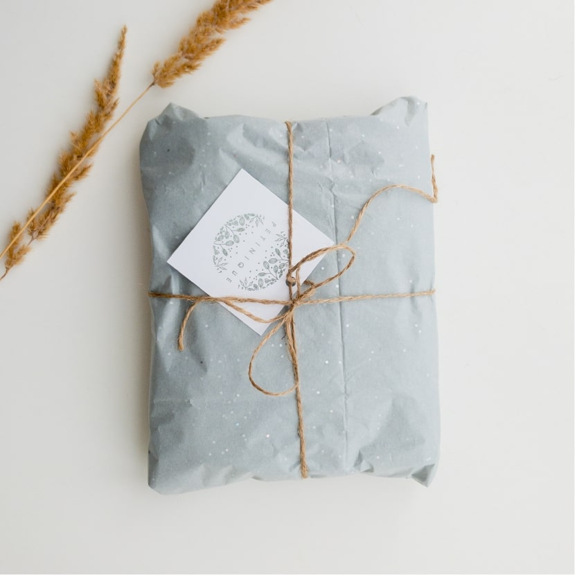 在白色的背景下，擺放了一份用藍色雪梨紙包裝好的產品。