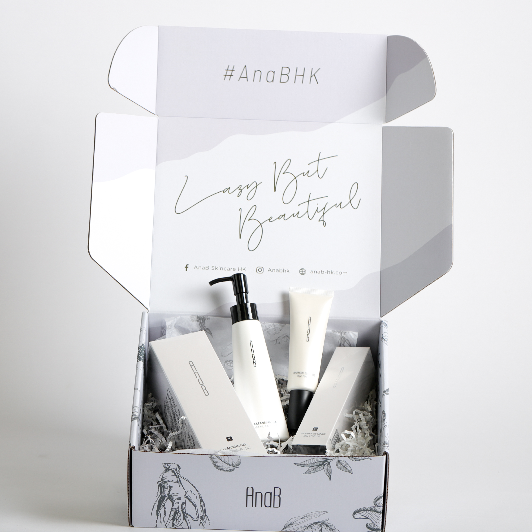 在白色的背景下，擺放了一個打開的白色郵寄盒，盒內裝有一套化妝品，並有填充紙條作保護。