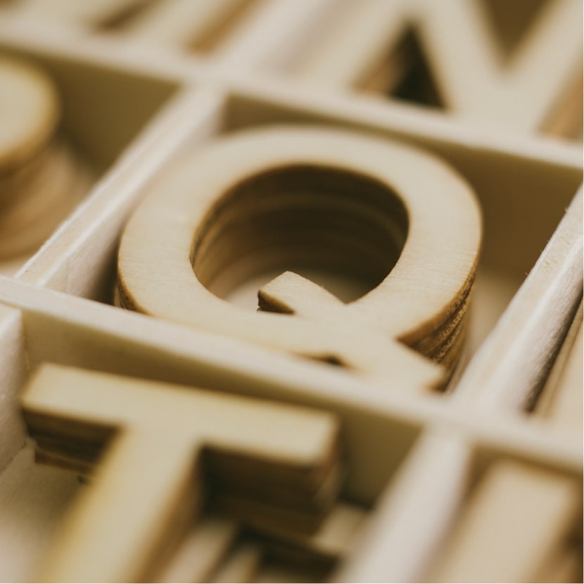 近鏡放大了放在木盤中的木製英文字母"Q"