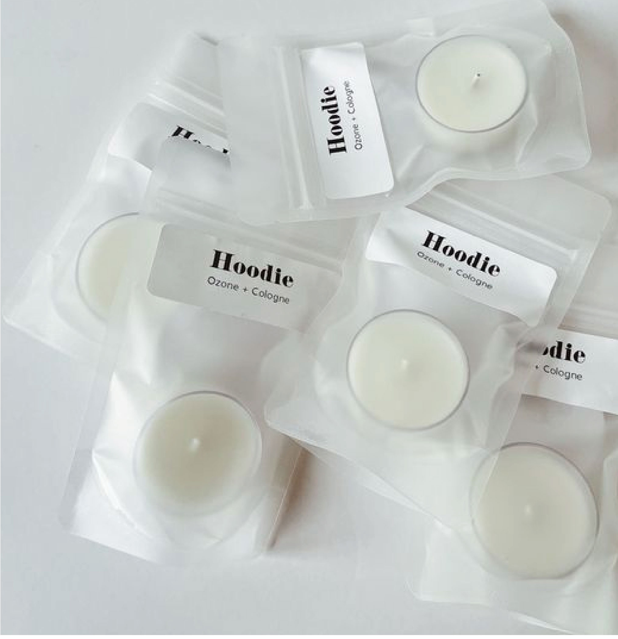 在白色的背景下，擺放了數多個用PP膠料包裝好的白色蠟燭，包裝上寫有"Hoodle"的字眼。