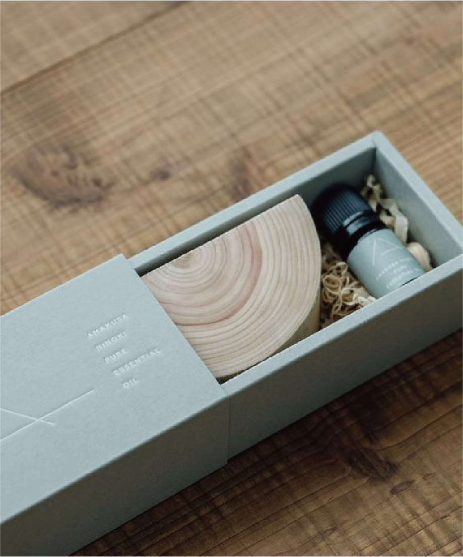 在一張木色枱上，擺放著一個粉藍的長方形盒，拉出後裡內擺放著木頭裝飾和產品。