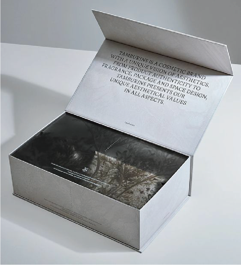 在白色的枱上放著一個白色的紙盒，裡面印有樹林的圖片，上方印有一段英文文字。