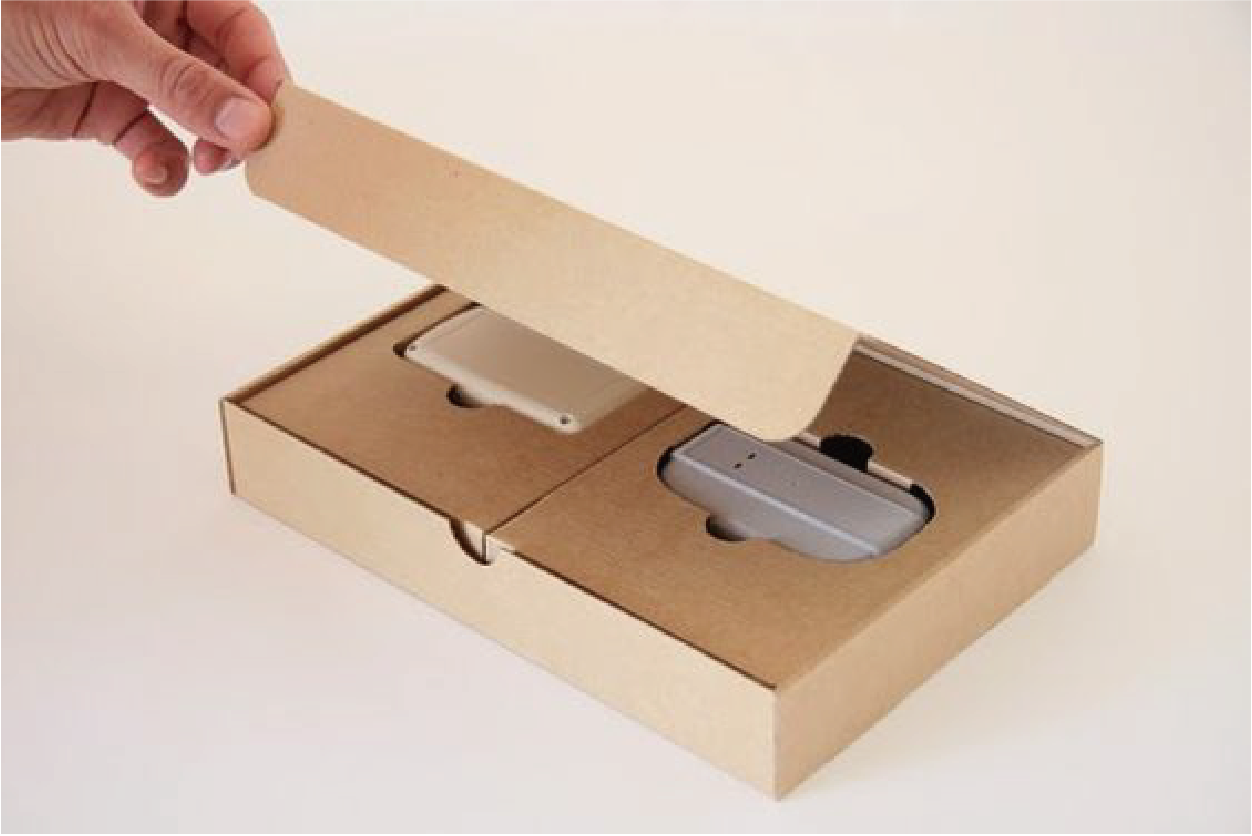 在米色的背景下，一位人士正在打開一個牛皮紙卡盒，裡面還有額外的保護內盒來保護產品。