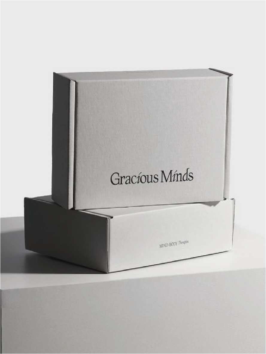 在灰色的背景下擺放了兩個郵寄盒，盒上寫著Gracious Minds。