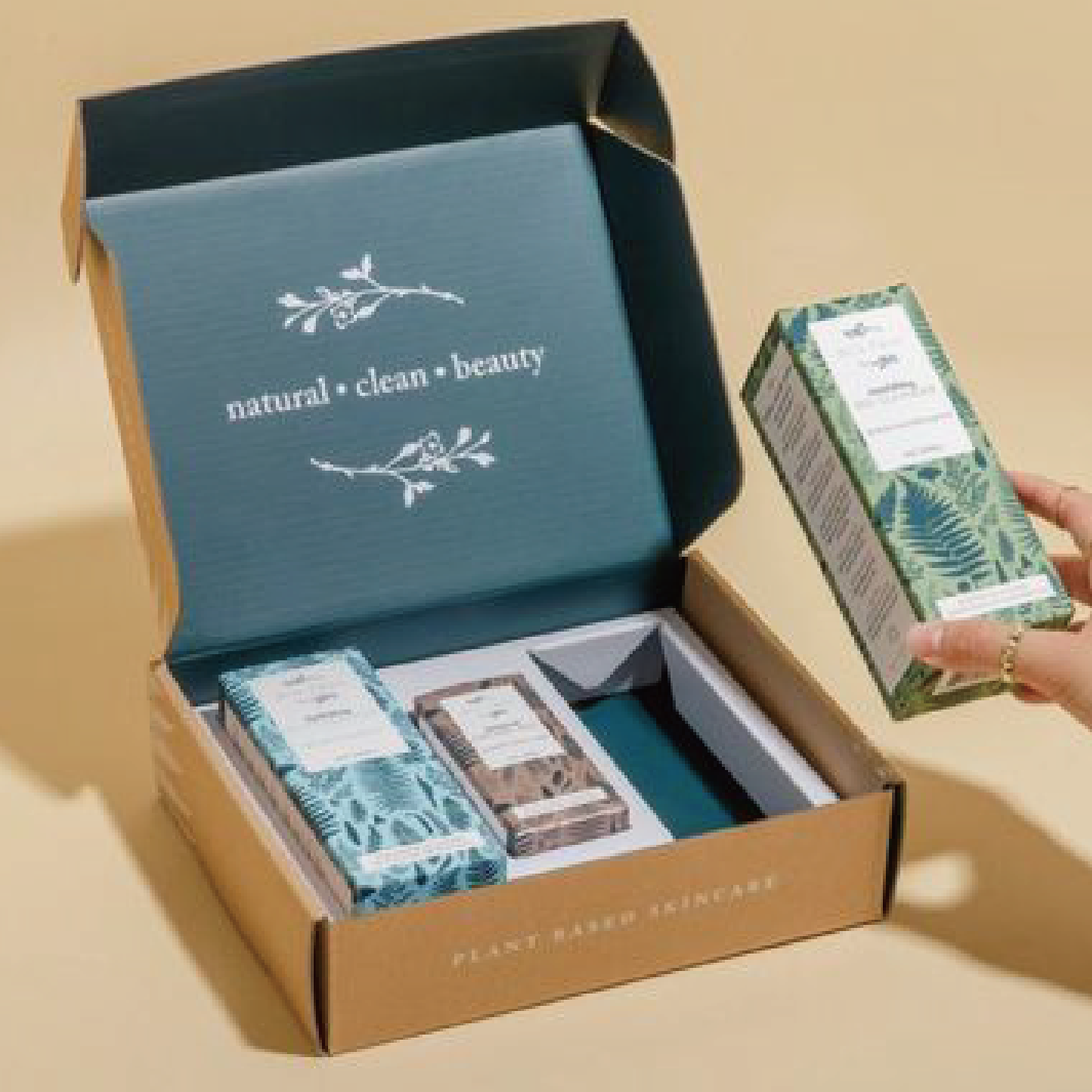 一個啡色的盒內是深綠色底印有白色的宣傳字樣與圖形，內裡擺放了三盒不同顏色的產品。