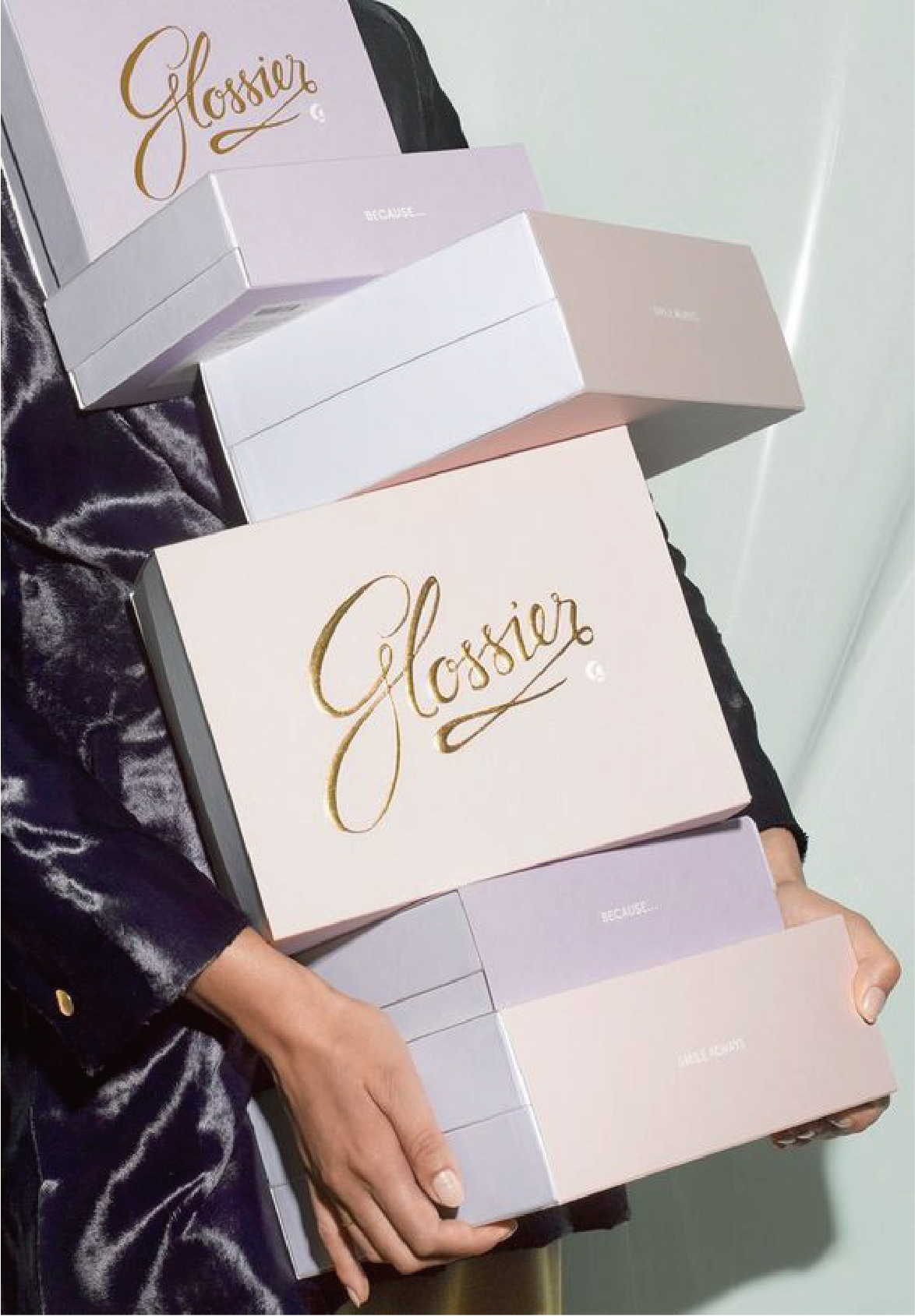 有一個人拿著六個不同顏色的盒，盒上印有金色的字樣。