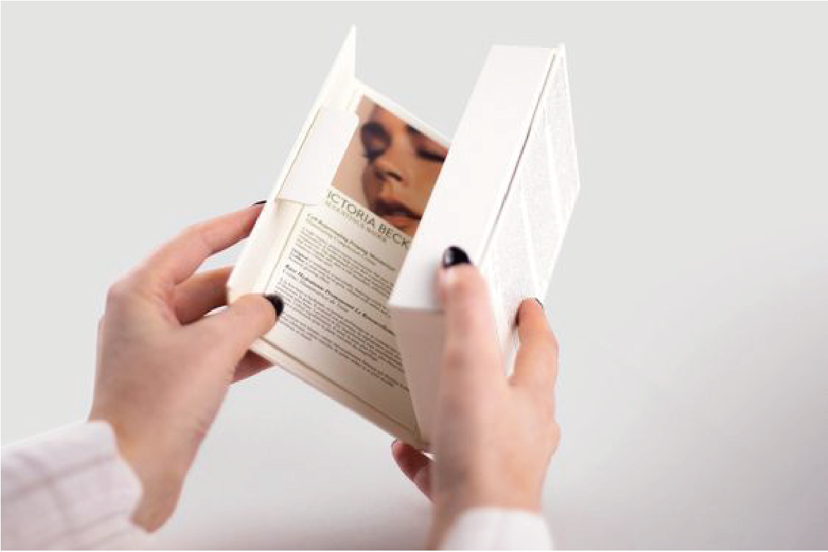 有一名女性雙手拿著一個白色盒，裡面印有產品說明和一名女姓的樣貌。