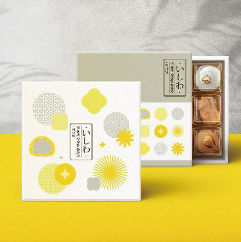 在上白下黃的背景下，正面擺放了一盒打開的黃色包裝的和菓子，盒面則是白色底，表面印有以象徵和菓子的黃色抽象圖案。