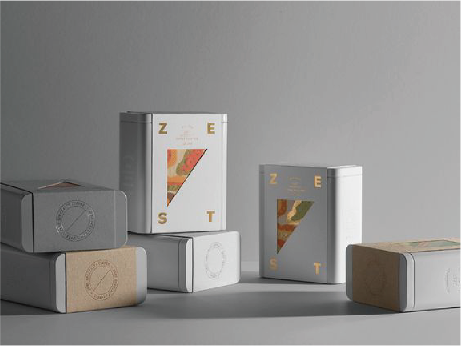 在白灰色的背景下，擺放了六個白色鐵盒，外面包著一張四角分別寫著"Z, E, S, T,"的金色字樣，中間有一個色彩繽紛的三角型圖像