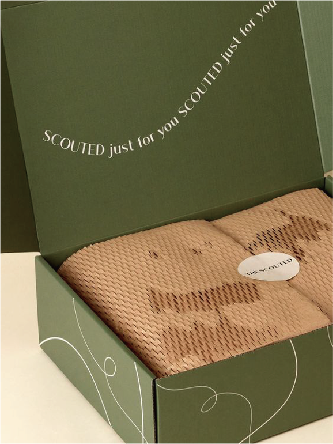 一個墨綠色的郵寄盒，盒內的產品以蜂巢網格包裝紙包裝。