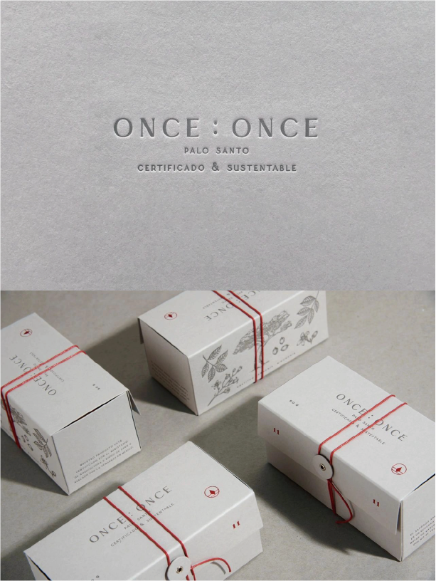 The image shows a set of delicate white boxes with the words "ONCE : ONCE" printed on them. The brand name and product features are highlighted in dark coloured lettering. It is tied with a red string to form a delicate bow.