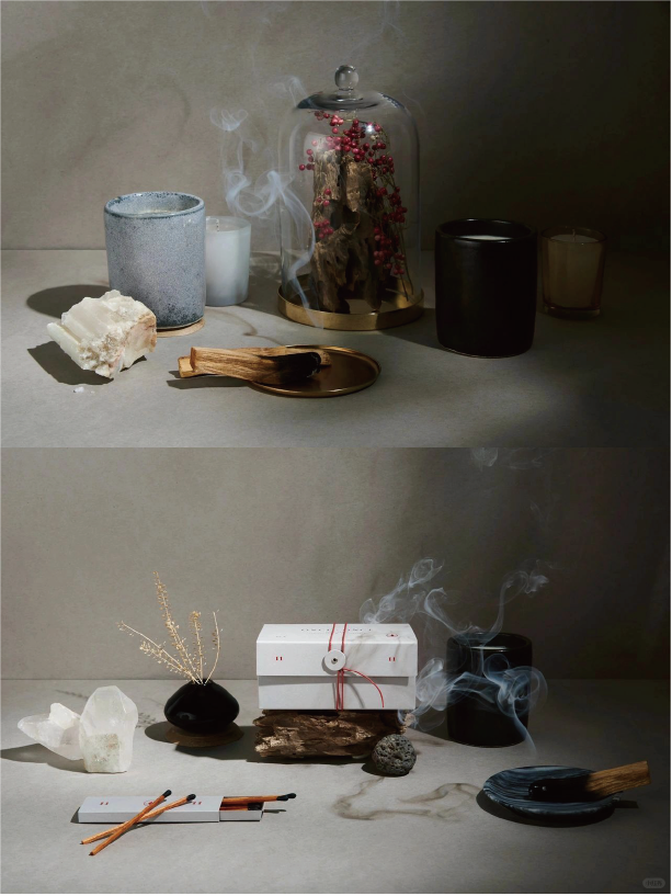 The top half displays a glass cover with red flowers and dead wood next to several different sized candles. The bottom half holds a white box with red string and several crystals, incense burners and scented potpourri.