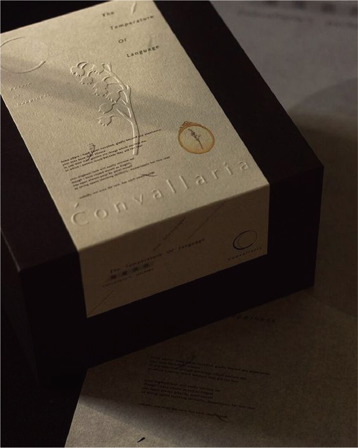 A premium box on a dark background with raised white botanical illustrations and text on the face of the box, with fine detailing to show the high end and natural theme of the product.