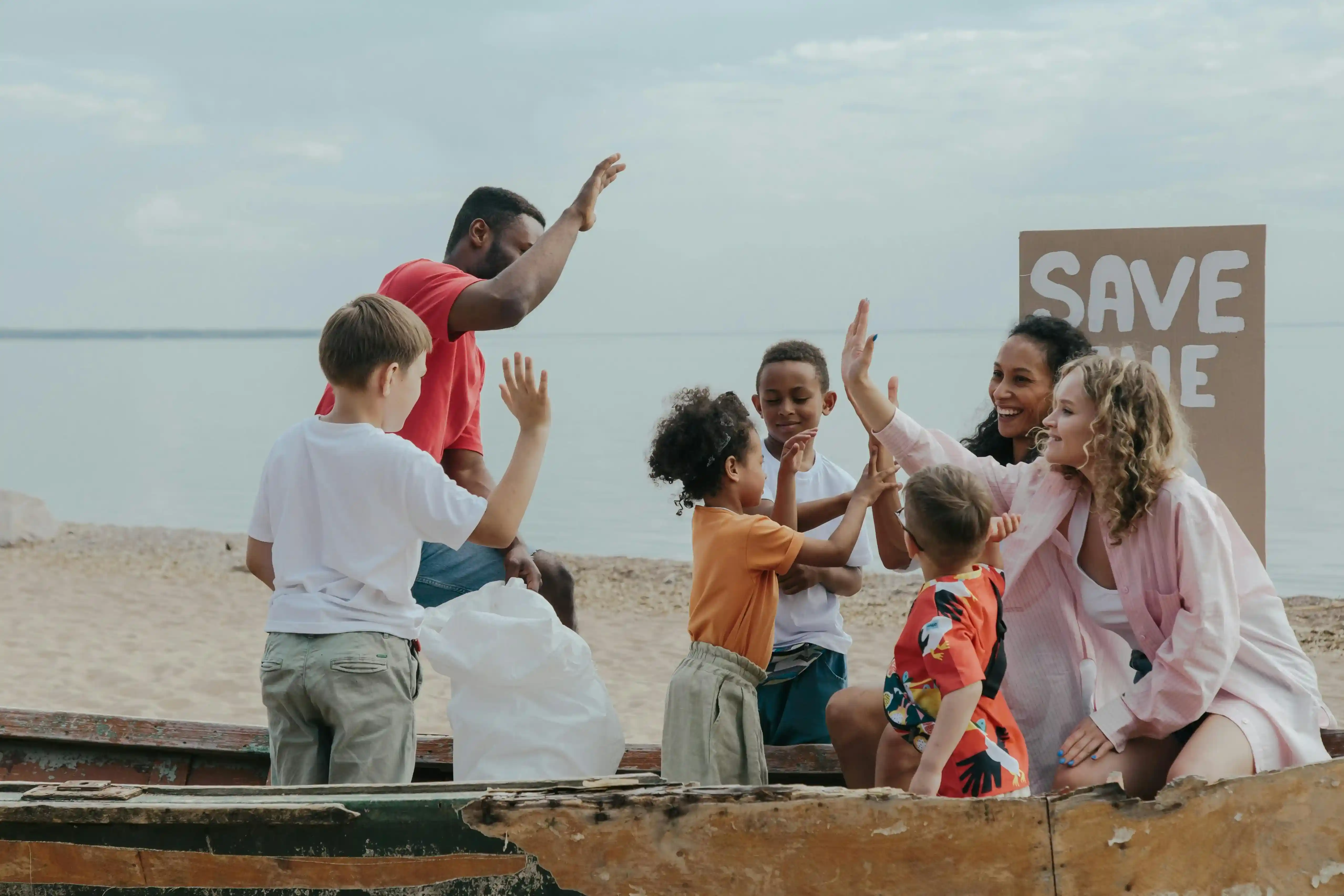 A group of people interacted with each other after the beach clean-up, with a sign behind them reading 'SAVE MARINE', demonstrating environmental awareness and community co-operation.